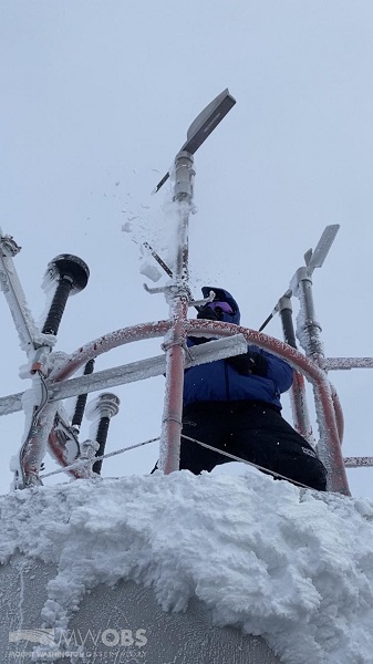 Observer Nicole de-icing the instrumentation on top of the tower in sustained 89 mph winds with gusts around 112 mph